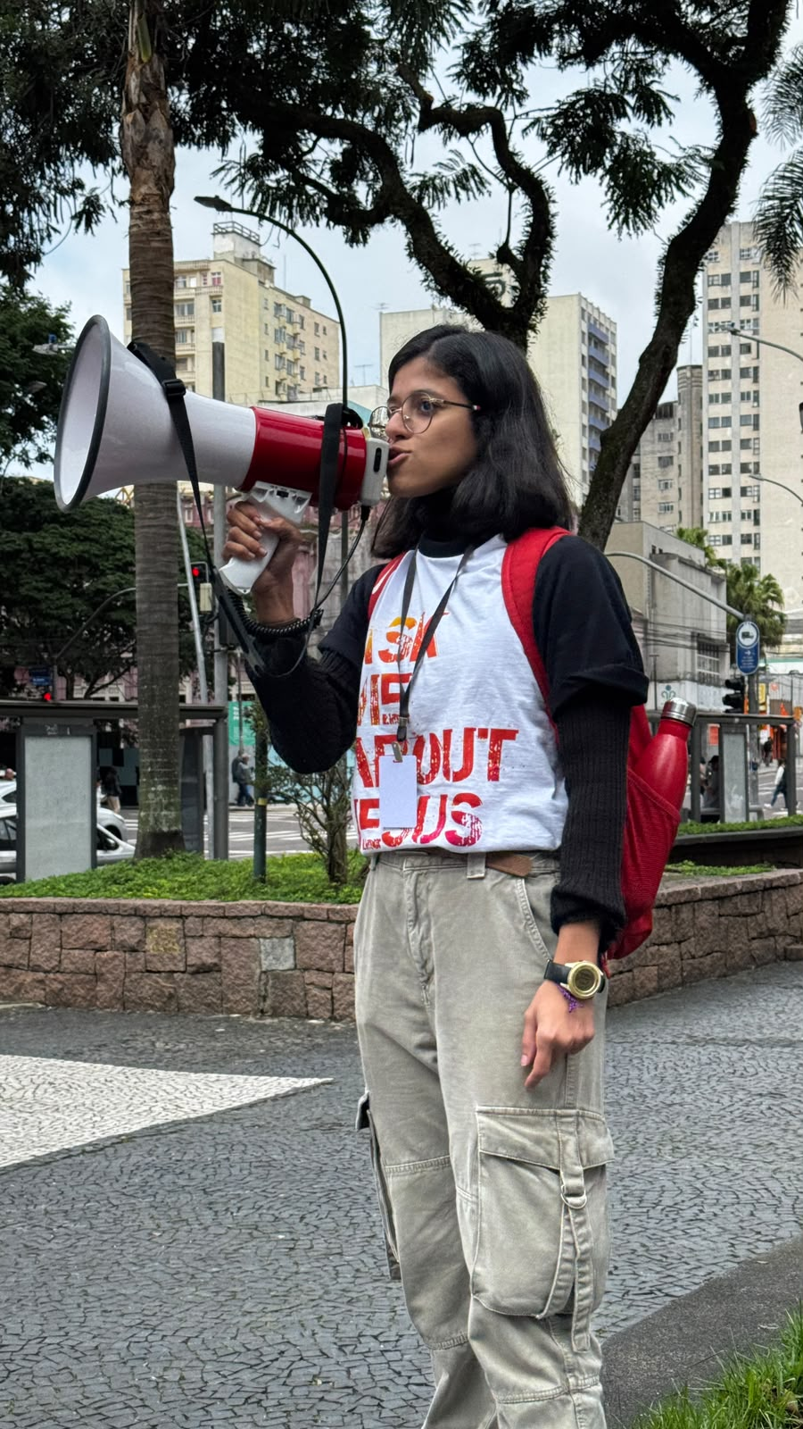 Aluna anunciando o Evangelho com megafone na praça