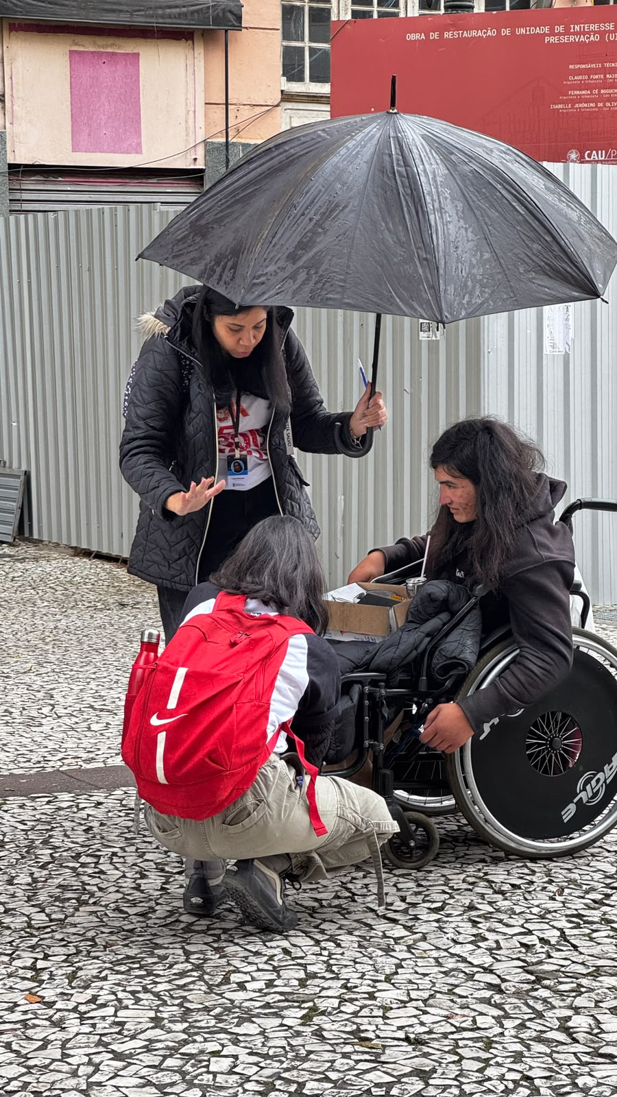 Alunos conversando e orando com uma pessoa na rua